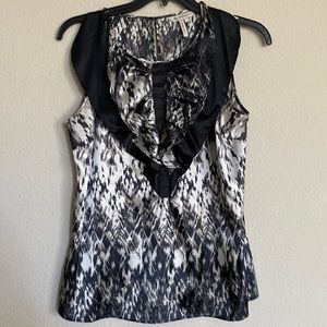 Black/white party blouse. Sleeveless with ruffle neck detail